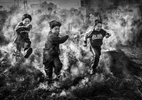 Three children jumping over fire