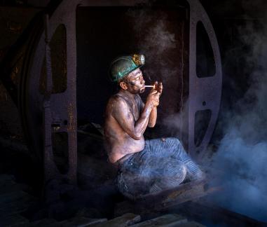 Miner lighting a cigarette