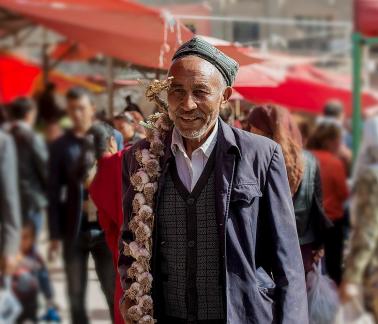 An elderly man selling garlic